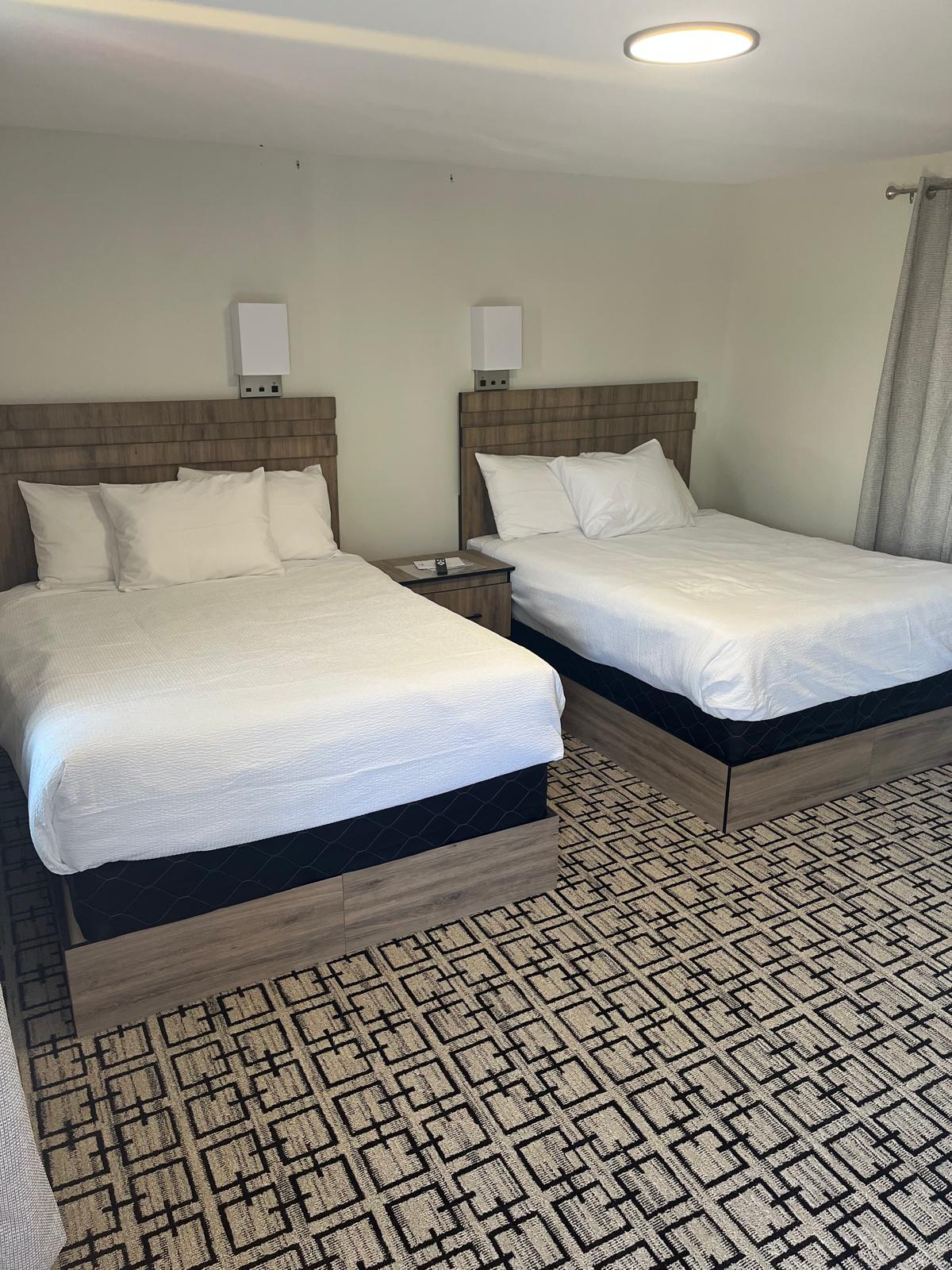 A clean motel room with two double beds